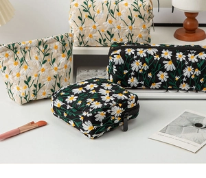 Detailed close-up of daisy embroidered canvas makeup bags with high-quality stitching