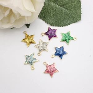 Detailed view of seven colorful glitter star charms with gold-plated metal frames