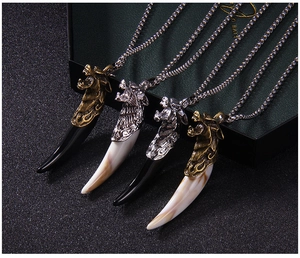 Detailed view of four wolf tooth pendant necklaces in bronze and silver finishes