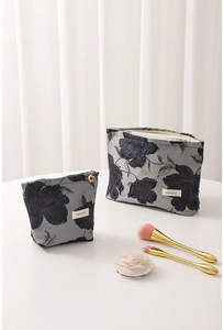 Close-up of vintage dark blue jacquard floral pattern on fabric makeup organizers