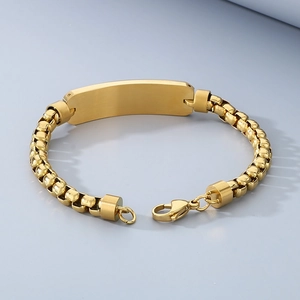 Close-up of golden stainless steel box chain bracelet featuring a curved ID tag for engraving