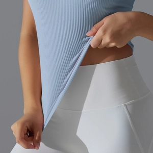 Gros plan sur la texture côtelée extensible du débardeur de yoga bleu clair de fitness