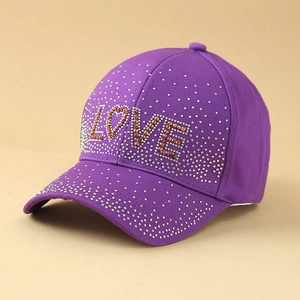 Close-up of purple cotton baseball cap featuring sparkling LOVE rhinestone lettering