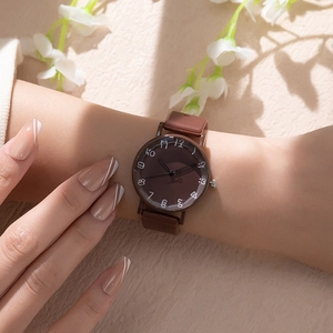 Close-up of a stylish brown quartz watch with white numerals worn on a female wrist