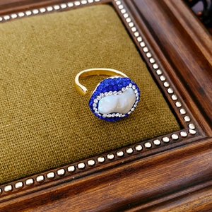 Macro detail of vintage gold plated ring with baroque pearl and crystal accents