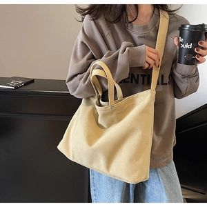 Detail of khaki canvas tote bag showing fine fabric texture and dual strap design