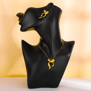 Elegantes 18k vergoldetes Set aus Halskette und Ohrringen mit Schleife auf schwarzem Modell