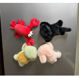 Detail of soft plush animal magnets including lobster and pig on a metal surface
