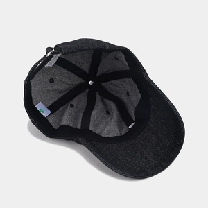 Inside view of black denim baseball cap with embroidery, sweatband, and metal buckle