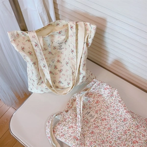 Detail showing two floral cotton tote bags with vintage prints and woven logo labels