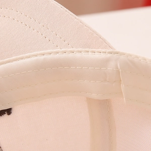 Close-up of the breathable sweatband and reinforced stitching on the beige baseball cap