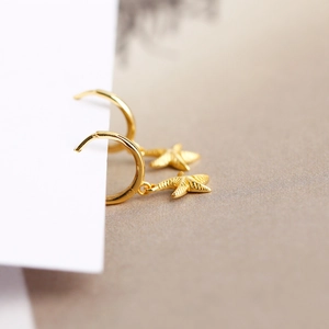 Close-up of golden S925 sterling silver starfish earrings with detailed metallic texture