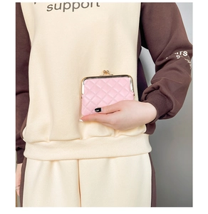 Detailed shot of a pink quilted mini coin purse with a vintage gold metal clasp closure