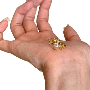 Vintage style gold fleur-de-lis cross ring with crystal stone on a model hand