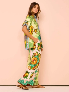 Detail of multi-color fruit print shirt and matching high-waisted trousers set for women