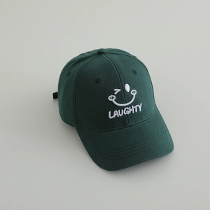 Detail of dark green baseball cap featuring white Laughty embroidery and a winking smiley face