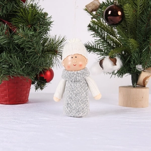 Detail of a Christmas plush boy doll with knit clothes and a resin face on a tree