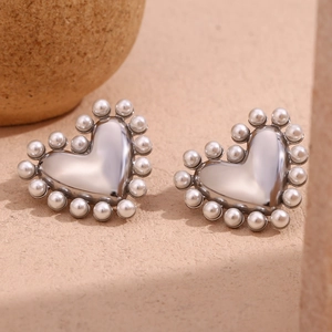 Macro shot of silver heart studs with polished finish and white pearl border detail