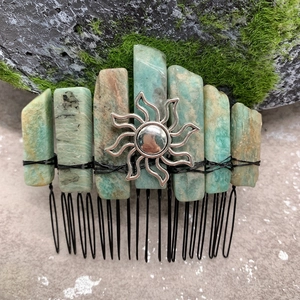 Detail of green natural crystal stones and silver sun pendant on a handmade hair comb