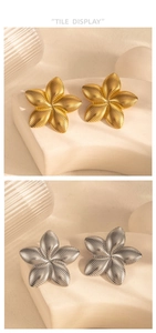 Dettaglio di orecchini a fiore argento e oro con strisce metalliche testurizzate