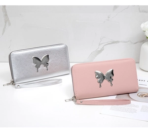 Detailed view of long zip wallets in pink and silver with metal butterfly charms