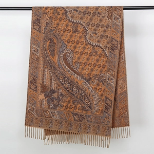 Detailed close-up of brown and grey paisley woven scarf with twisted fringe tassels
