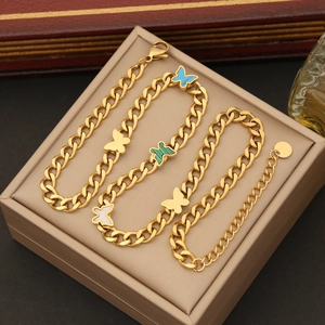 Detailed shot of golden butterfly necklaces on a beige display cushion with colorful charms