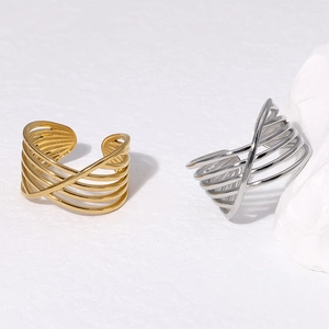 Crossed multi-layer geometric open rings in gold and silver finish on white stone