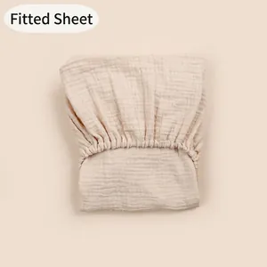 Detailed close-up of cream double gauze muslin cotton fitted sheet with elastic hem