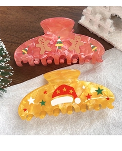 Detail von rosa Lebkuchenmann und gelben Weihnachtsmannhut Haarklammern mit festlichem Muster