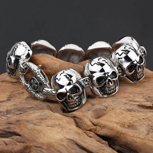 Rock style silver skull bracelet in stainless steel displayed on weathered wood bark