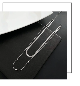 Detail of silver double-layered necklace with bead chain and flat snake chain design