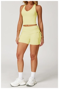 Detail of yellow yoga set showing ribbed high waist shorts with side drawstring cords