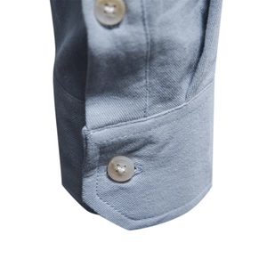 Macro detail of light blue cotton shirt cuff featuring double buttons and fine twill texture