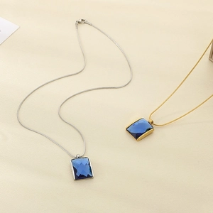 Detail showing gold and silver snake chains with rectangular blue crystal pendants