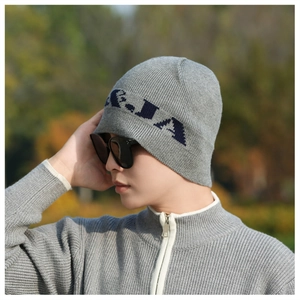 Detail of dark grey knitted beanie with ribbed texture and navy blue jacquard pattern