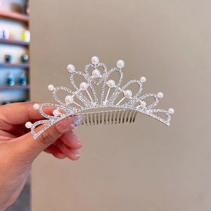 Close-up of girls' crown hair comb with sparkling rhinestones and white pearls