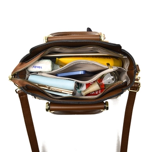 Brown leather handbag interior with spacious compartments and gold metal hardware