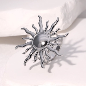 Macro shot of silver sunburst stainless steel ring on white textured stone background