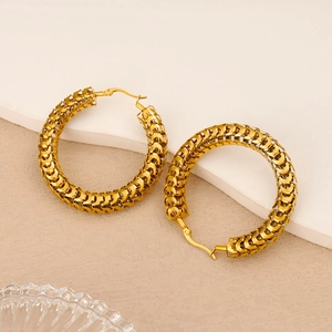 Detailed view of hollow chunky gold hoop earrings with intricate woven fish scale texture
