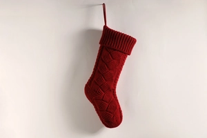 Detail of red knitted Christmas stocking with vintage cable knit texture and hanging loop