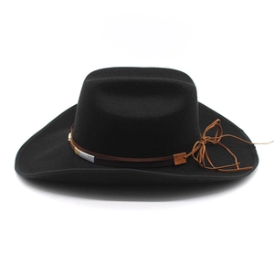 Detail of black wool felt western cowboy hat with brown leather band and metal accents