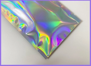 Detailed macro view of holographic silver self-sealing mailer with iridescent rainbow gloss