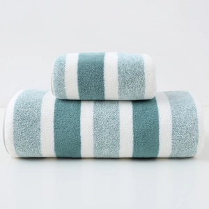 Detail of blue and green striped cotton towels showing soft terry texture and fine fibers