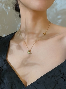 Elegante collana dorata con farfalla 3D indossata da una modella con due ciondoli fini