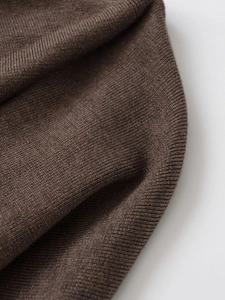 Makroaufnahme von braunem Strickgewebe mit detaillierter weicher Textur und Muster