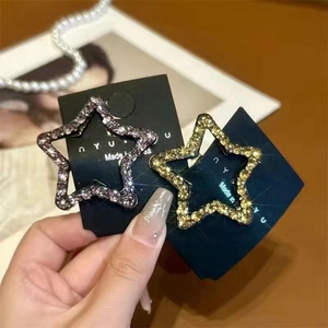 Nahaufnahme glitzernder Stern-Haarspangen mit bunten Strasssteinen auf einer Karte