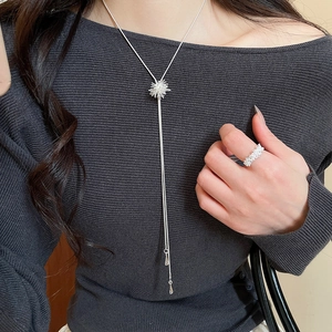 Close-up of model wearing silver zircon snowflake tassel necklace and matching ring