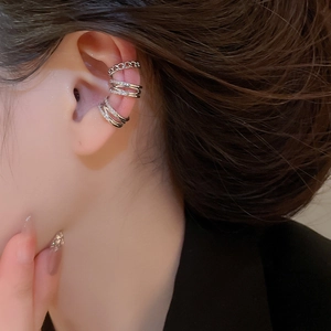 Close-up of silver-plated ear cuff set with shiny cubic zirconia on model's ear