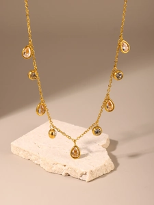 Detail of 18k gold plated stainless steel necklace with water drop zircon pendants on stone